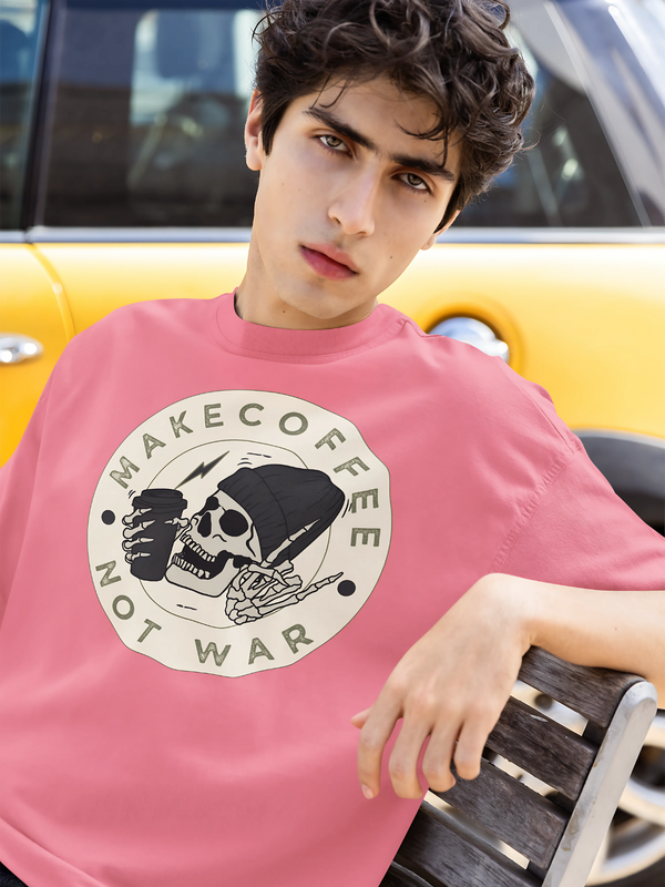 Person wearing a pink t-shirt with a graphic design in front of a yellow car.