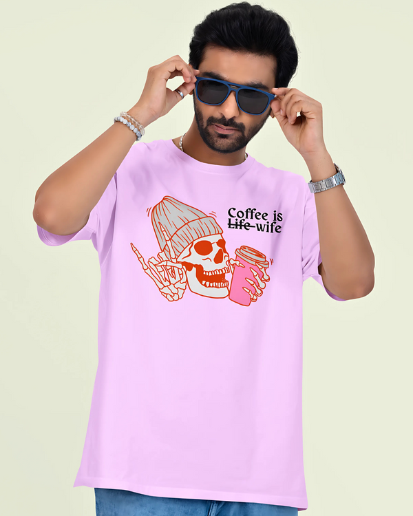 Man wearing a pink t-shirt with a coffee-themed design and sunglasses on a light green background